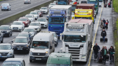 People walk along motorway towards Dublin Airport as fuel protests continue